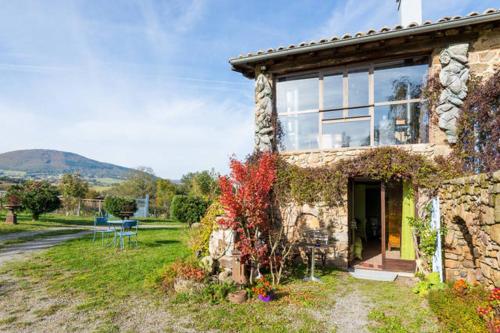 une maison en pierre avec une grande fenêtre dans l'établissement La Verdine, à Vérin