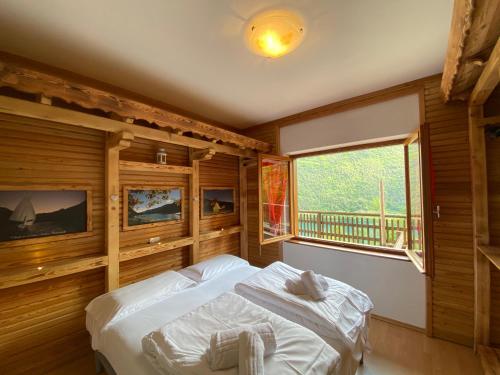 皮耶韋迪萊德羅的住宿－Ca' Romantica - Ledro House，一间卧室配有一张带木墙和窗户的床。