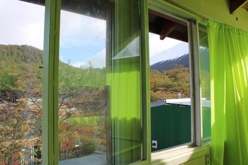 a green window with a view of a mountain at Caballo de Fuego in Ushuaia