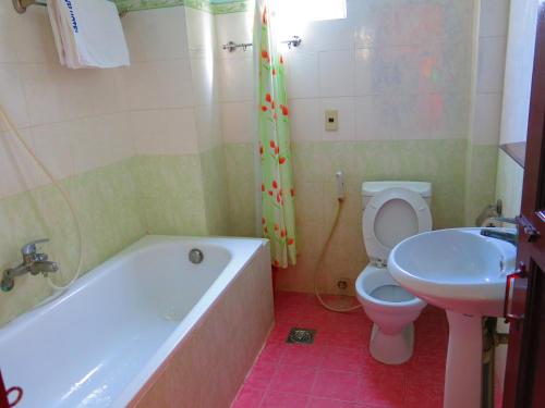ein Badezimmer mit einer Badewanne, einem WC und einem Waschbecken in der Unterkunft Quang Vinh 2 Hotel in Nha Trang