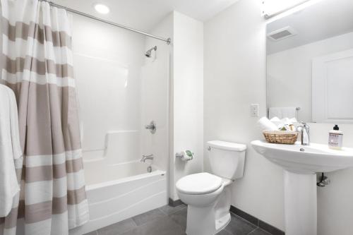 a bathroom with a toilet and a sink and a shower at Porter Sq 2BR w WD Elevator by Davis Station BOS-319 in Somerville
