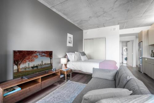 a living room with a bed and a couch at Calming Kendall Sq Studio w Gym nr MIT BOS-42 in Cambridge