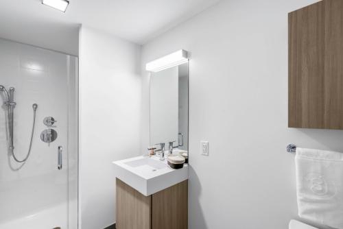 a white bathroom with a sink and a shower at Calming Kendall Sq Studio w Gym nr MIT BOS-42 in Cambridge