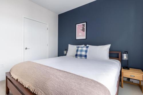 um quarto com uma cama grande e uma parede azul em Somerville 1BR w Gym Doorman nr Assembly Row BOS-228 em Somerville