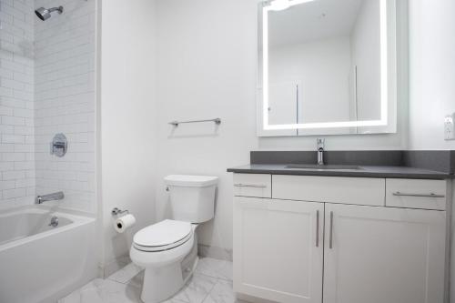 a white bathroom with a toilet and a sink at Somerville 1BR w Gym Doorman nr Assembly Row BOS-228 in Somerville