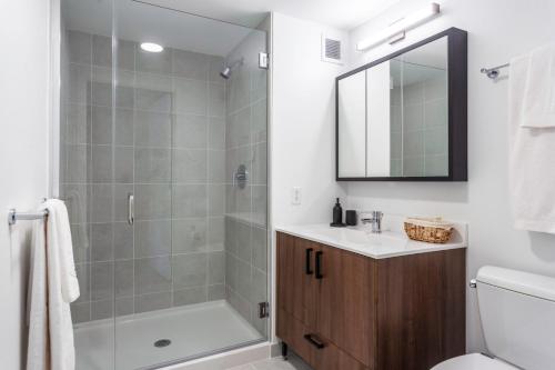 La salle de bains est pourvue d'une douche, d'un lavabo et de toilettes. dans l'établissement Central Sq 1BR w Gym Doorman Roof BOS-314, à Cambridge