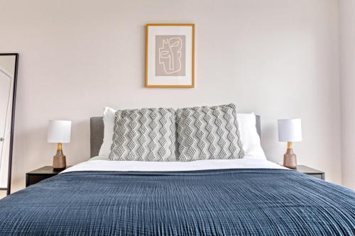 a bedroom with a bed with a blue blanket and two lamps at Newly development 1BR w WD Gym in Cambridge BOS-462 in Boston