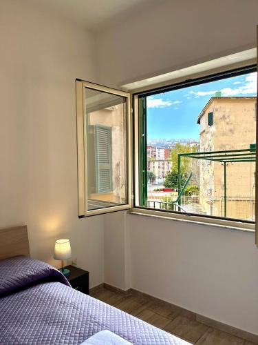 a bedroom with a bed and a large window at Il Rifugio Dei Partenopei in Naples