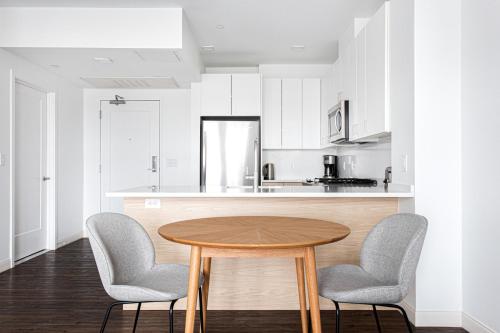 a kitchen with a wooden table and two chairs at 1BR w Gym WD Steps from Newtonville Train BOS-353 in Newton