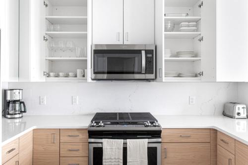 a kitchen with a stove and a microwave at 1BR w Gym WD Steps from Newtonville Train BOS-353 in Newton