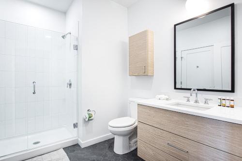 a bathroom with a toilet and a shower and a sink at 1BR w Gym WD Steps from Newtonville Train BOS-353 in Newton