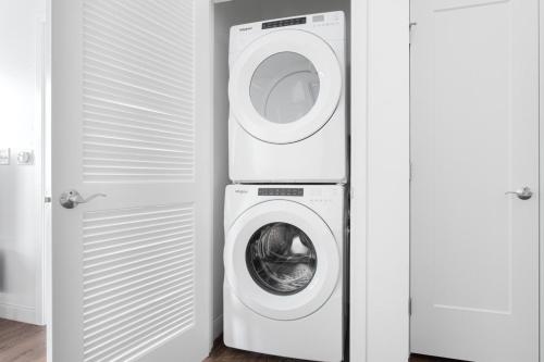a washer and dryer in a room with a washing machine at 1BR w Gym WD Steps from Newtonville Train BOS-353 in Newton