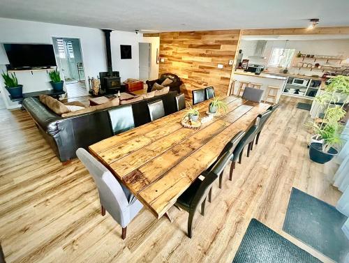 a large wooden table in a living room with a couch at La Couronne boréale in Rivière-Rouge