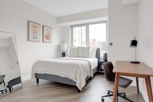 a white bedroom with a bed and a desk at E Cambridge 1BR w WD Gym steps from Train BOS-524 in Boston