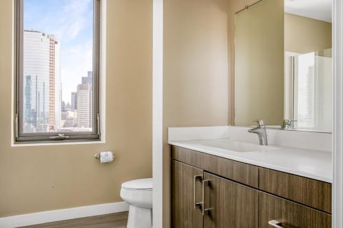 ein Bad mit einem Waschbecken und einem WC mit einem Fenster in der Unterkunft N Station 1BR w Gym WD nr TD Garden BOS-638 in Boston