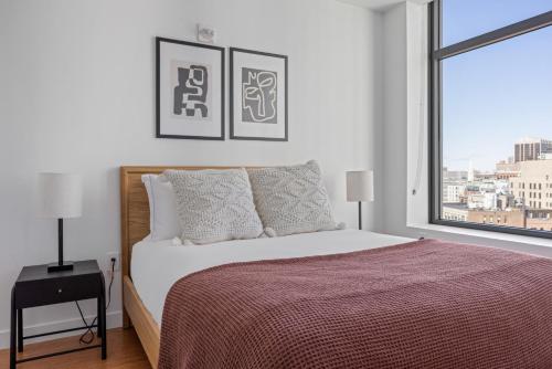 a bedroom with a bed and a large window at DowntownFinancial District 1br w wd gym BOS-800 in Boston