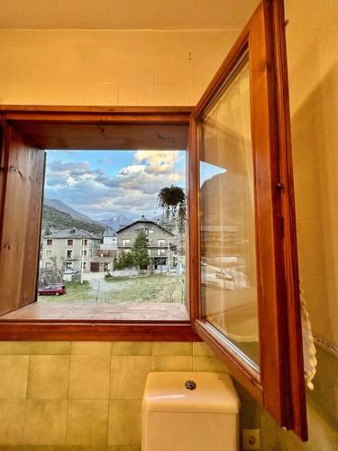 ventana sobre un aseo con vistas a un edificio en L'allotjament rústic d'Ainet, en Vall de Cardós