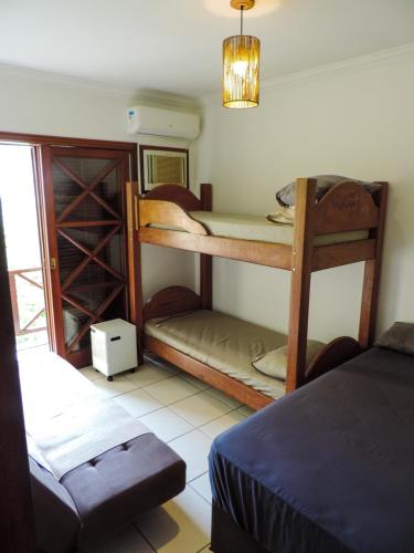 a room with two bunk beds and a couch at Casa Canto do Mar Maresias 2 in Maresias