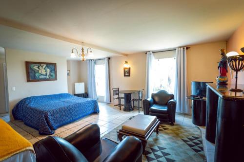 ein Schlafzimmer mit einem Bett, einem Sofa und Stühlen in der Unterkunft Hotel Highlander in Gravatá