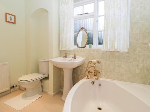 a bathroom with a tub and a toilet and a sink at Poets Corner in Great Malvern