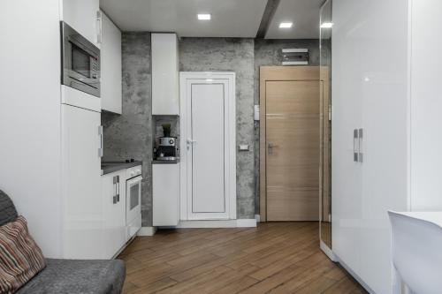 Luxury Studio Silver by Flat Mаnager في صوفيا: غرفة معيشة مع أريكة ومطبخ