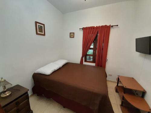 a bedroom with a bed and a desk and a television at Hotel y Jardines Casa Búho in Antigua Guatemala