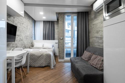a bedroom with a bed and a table and a couch at Luxury Studio Silver in Sofia