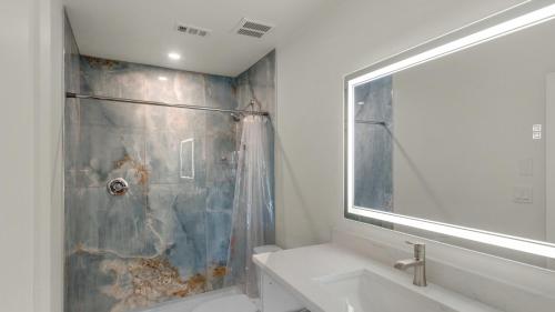 a bathroom with a shower and a sink and a mirror at Hidden Beach 219 in Santa Rosa Beach