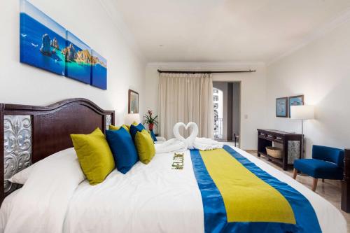 1 dormitorio con 1 cama grande con almohadas azules y amarillas en Stunning Cabo San Lucas Villa at 5-Star Resort!, en Cabo San Lucas