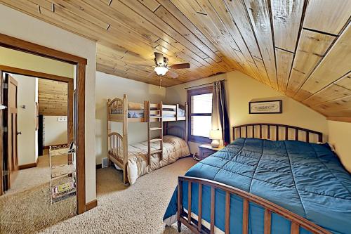 - une chambre avec un lit et un plafond en bois dans l'établissement Ravensong Lodge, à New Auburn