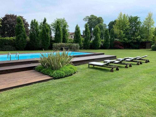 eine Reihe von Liegen neben einem Pool in der Unterkunft Villa Paradiso nel verde in Ponte San Marco