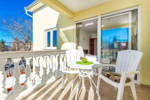 a balcony with white chairs and a white table and chairs at Holiday home in Dramalj 5745 in Dramalj