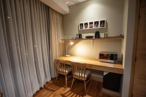 a room with a desk with chairs and a microwave at Hotel Boutique Rosario Sur in La Paz