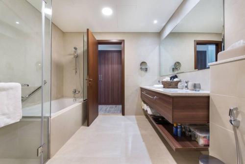y baño con bañera, lavamanos y ducha. en Stunning Views & Palm Marina Views & 39th floor, en Dubái