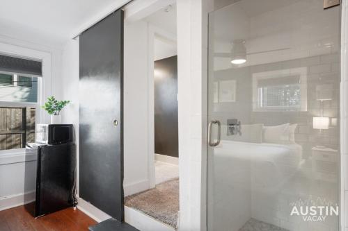 a bathroom with a shower and a glass door at Prime Location w King Accommodations Near Downtown in Austin