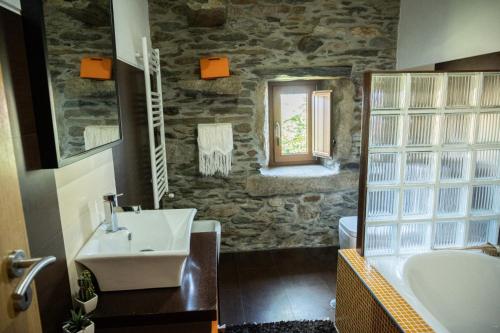 a stone bathroom with a sink and a tub and a sink at Casa da Ferreira_Vila Real in Vila Real
