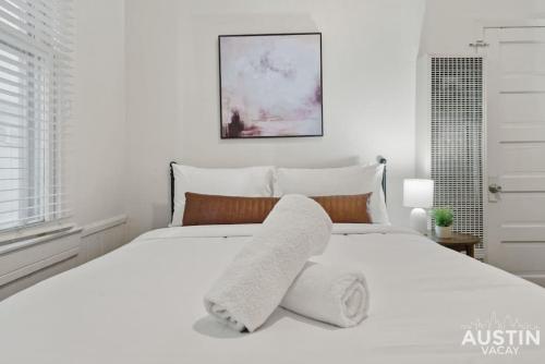 a white bedroom with a large white bed at Cozy Mid-Century Modern Vibes in Central Location in Austin