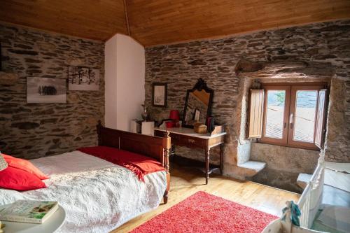 a bedroom with a bed and a table and a window at Casa da Ferreira_Vila Real in Vila Real