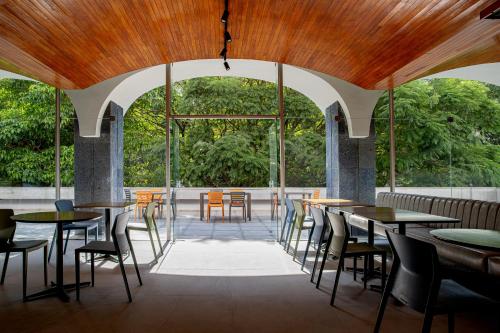 a restaurant with tables and chairs and a large window at Sooz Hotel Collection in Sao Paulo