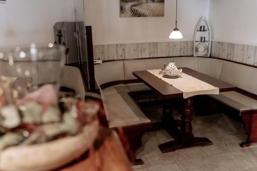 a small table and bench in a room with a table at Hotel-Restaurant Nordlicht in Kappeln