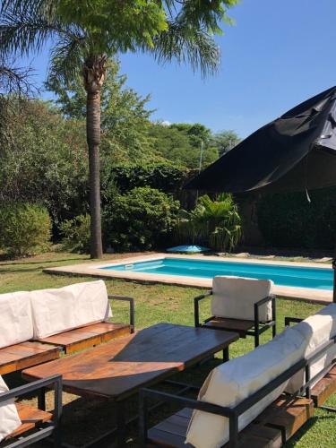 una piscina con mesa de picnic y sillas junto a una piscina en Casa en Córdoba Zona Norte en Córdoba