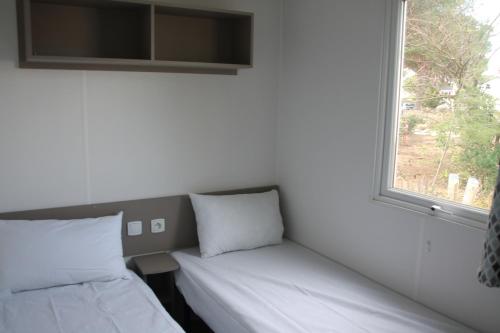Ένα ή περισσότερα κρεβάτια σε δωμάτιο στο mobil home au lac des rêves