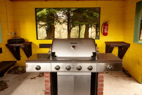 a kitchen with a stove in a yellow wall at Mount Brandon Cottages Graiguenamanagh in Graiguenamanagh