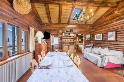 a dining room with a long table and a couch at Chalet complet in Antey-Saint-André