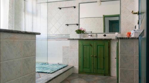 La salle de bains est pourvue d'une porte verte et d'un lavabo. dans l'établissement Cala Gonone house, à Cala Gonone