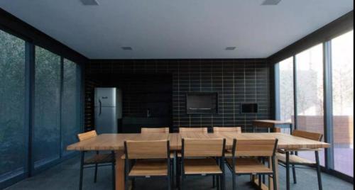 una sala da pranzo con un grande tavolo in legno e sedie di Studio Ben a San Paolo