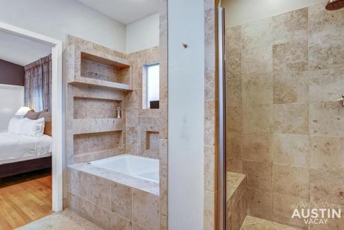 uma casa de banho com um chuveiro e uma banheira em Fun For the Whole Family - Easy Access to Downtown em Austin