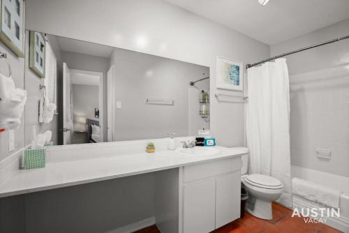 a white bathroom with a sink and a toilet at Enjoy Central Austin King Bed Smart TV and AC in Austin