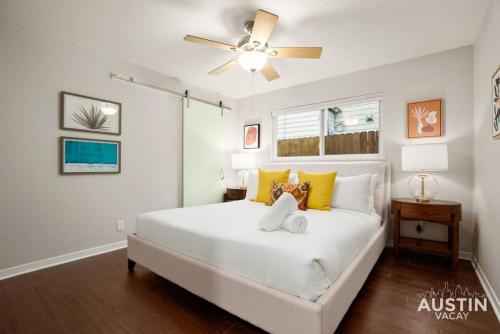 1 dormitorio con cama blanca y ventilador de techo en Retro Chic Old Austin Charm with Updated Features en Austin