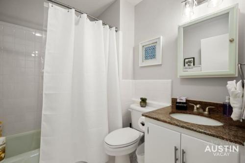 y baño con aseo, lavabo y ducha. en Retro Chic Old Austin Charm with Updated Features en Austin